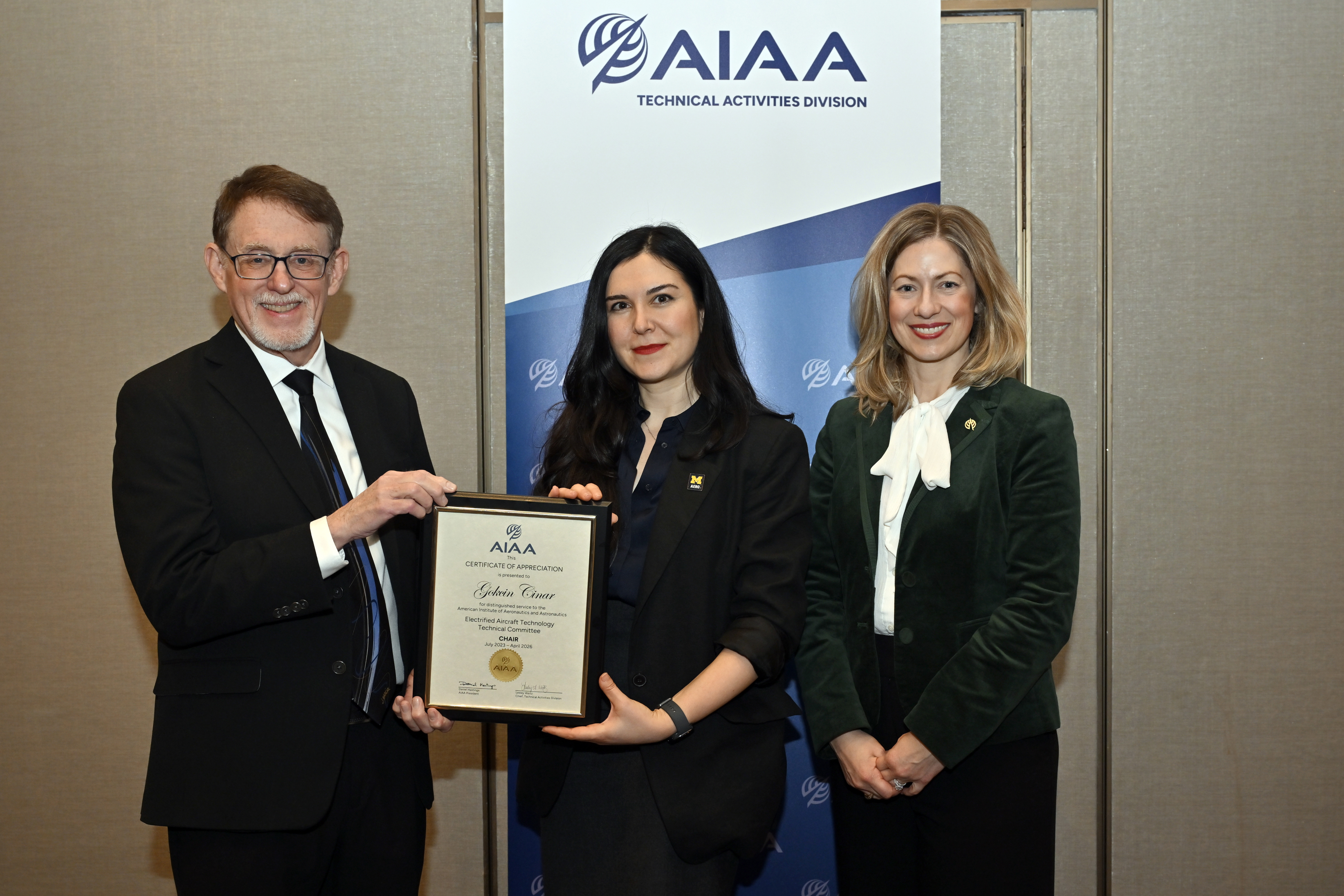 Gokcin Cinar receiving the AIAA TC Chair plaquet.